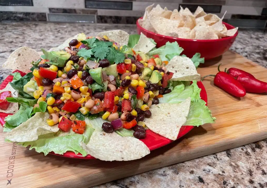 Cowboy Caviar on a plate with chips on a board