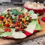 Cowboy Caviar on a plate with chips on a board