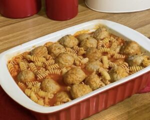 Pasta and meatballs with sauce in baking dish